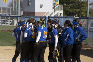 The softball team huddles for disccusion during a timeout. LAUREN MARRETT | THE HARBINGER