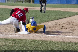 A Cougars baseball player slides back into first base. LAUREN MARRETT | THE HARBINGER