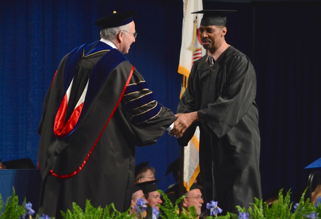 David Lewis, right, shakes the hand of Provost William Tammone. Lewis has worked for ICC as a housekeeper for more than a decade and today got his degree. REID|HARBINGER